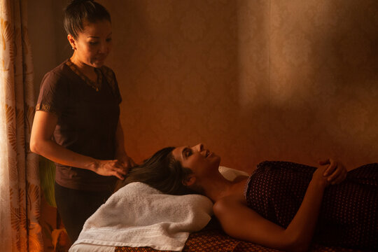Thai female massagist preparing to give a massage to a young woman