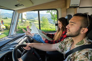 Traveling couple driving camper during summer trip