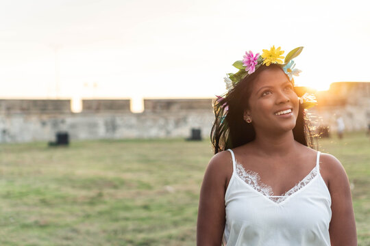 Charming ethnic woman in flower wreath in summer