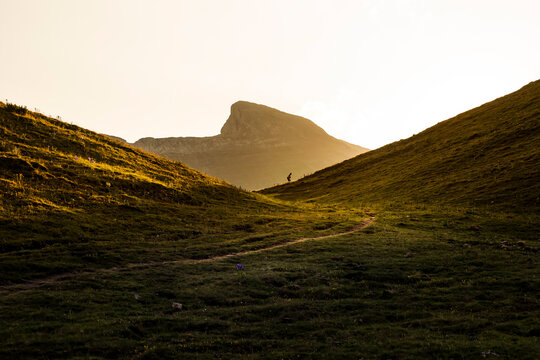 Lonely Traveler Walking Along Grassy Hills