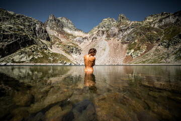 Woman taking bath in mountain lake