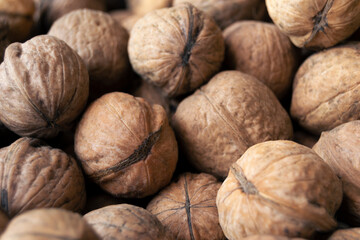 Heap of raw walnuts close-up as background.