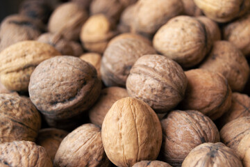 Heap of raw walnuts close-up as background.