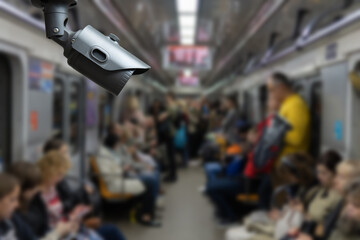 Security camera monitoring attach on ceiling inside subway metro train to surveillance safety of passenger in rush hour and can watch all time, blur people background.