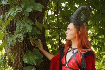 Sensual gothic girl with horns and leather harness, Halloween theme, sexy woman in lingerie