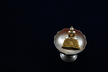 Golden little monk in a brass cup