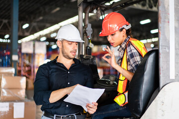 Male factory foreman holding document discuss and explain work project to female worker on forklift...