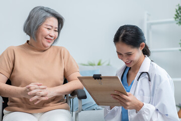 Fototapeta premium Asian doctor showing health checkup report to grandmother and giving advice. medical assisted living visit senior patient at home. Home nursing and healthcare caregiver concept