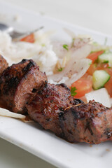 Seekh Kabab, Naan bread, and sauce on a plate 
