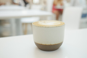 a cup of late coffee with flower shape design on top at cafe 