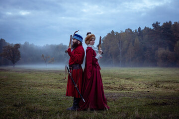 Duel of a man and a woman in 17th century costumes using antique pistols. Enemies stand back to...