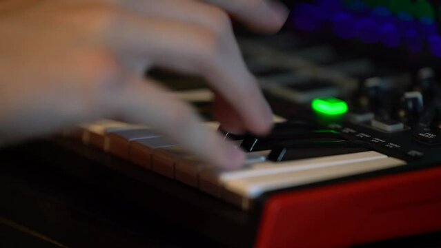 Playing piano chords on small mini MIDI controller keyboard to produce music