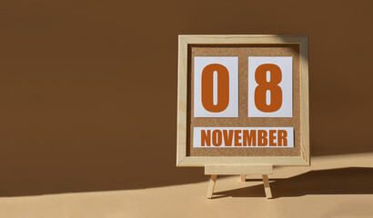 November 8th. Day 8 of month, Calendar date. Cork board, easel in sunlight on desktop. Close-up, brown background.  Autumn month, day of year concept