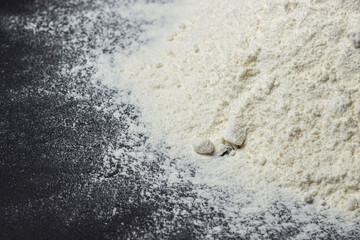 Flour on a black background. Home baking concept