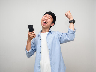 Young businessman hold cell phone and show fist up happy with successful isolated
