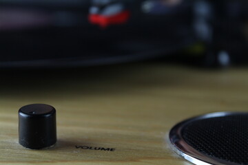 close up volume button and speaker with wooden vinyl player background. Selective focus planning