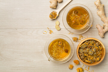 Herbal tea with ingredients on wooden background, top view