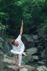 the guy performs the balance asana on one leg. meditation in nature.