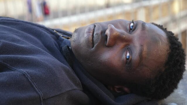 Handsome black african man lying staring at the camera outdoor