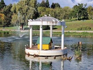 a round gazebo stands in a picturesque place in the park