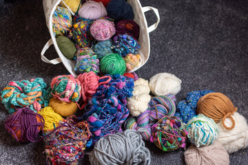 yarn stash - a pile and basket of balls of wool for knitting and crochet in  a crafters living room 