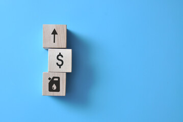 wooden cubes with an arrow, dollar signs and a fuel sign. Symbol of rising fuel prices