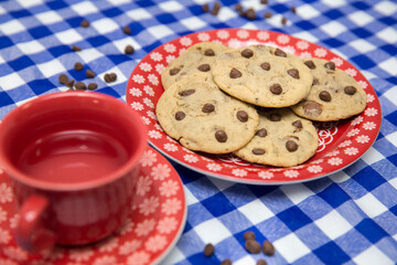 chocolate chips cookies on a plate and a cup of tea