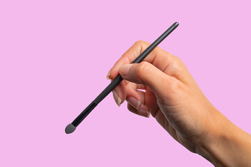Makeup brush held by a hand