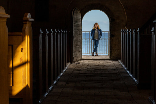 Stevns Klint, Denmark,  A woman stands under an arch overlloking the Baltic Sea in the old Hojerup Church.