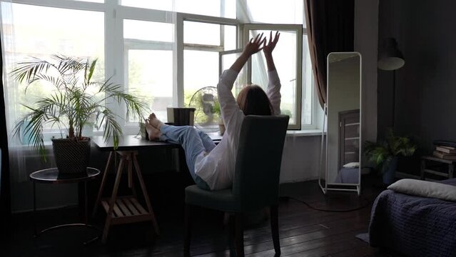 A woman in a white shirt is resting in a home office