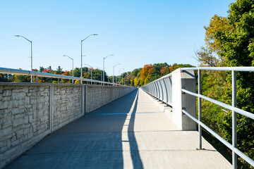 Obraz premium Walkway on a Bridge Over Credit River Ontario With Colorful Fall Foliage Surrounding It