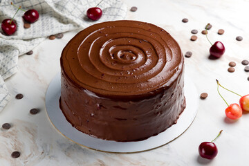 chocolate cake with cherries on white marble table