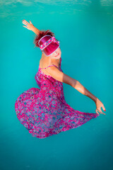 Femme se baignant avec sa robe dans la piscine