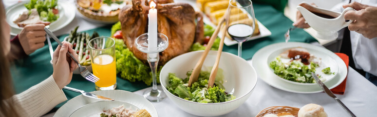 partial view of family near thanksgiving diner with delicious turkey and vegetable salad, banner