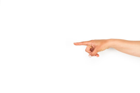 Mano de mujer señalando y apuntando con el dedo indice sobre un fondo blanco liso y aislado. Vista de frente y de cerca. Copy space