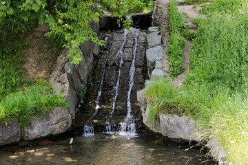 small artificial waterfall paved with huge stones