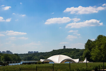 Recreation area for vacationers on the river with benches and a white dome in the midst of gum trees