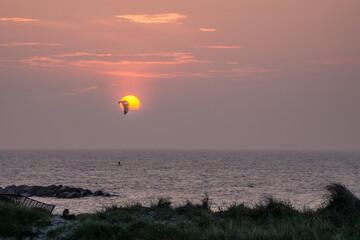 A kiter in front of a scenic sunset