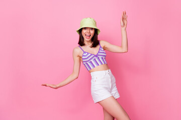 Portrait of young dancing funny lady wear cute cap mini shorts party summer chill disco drunk isolated on pink color background