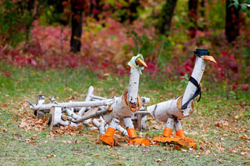 Figures of white geese from logs.