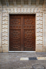 Closed old door with carved wooden symmetrical ornaments