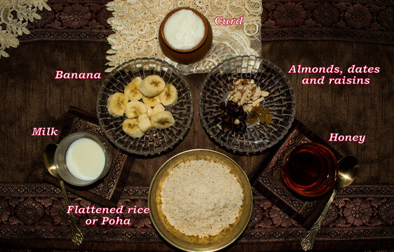 Healthy Indian breakfast cereal recipe Flattened rice, curd, fruit, nut and honey in brown background. Healthy for kid and adult. No cooking, jain food, easy prepare concept. Chura or chiwda Dahi.