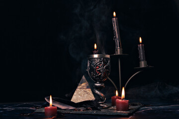 Witchcraft composition with burning candles, jewelry and pentagram symbol. Halloween and occult...