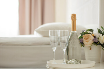 Two glasses and a bottle of champagne in a hotel room. Dating, romance, honeymoon, Valentine's day.