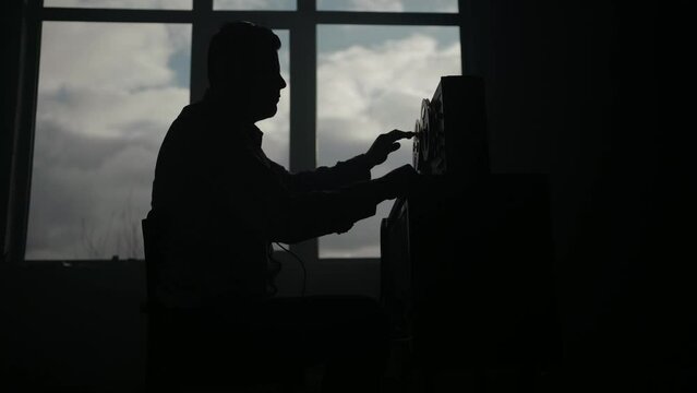 Secret agent listens on the reel tape recorder. Officer wiretapping in headphones. Spying of conversations. Intelligence gathering. Espionage concept. Report information to superiors.
