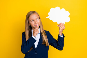 Photo of minded clever smart girl arm hold white paper bubble look empty space consider answer isolated on yellow color background