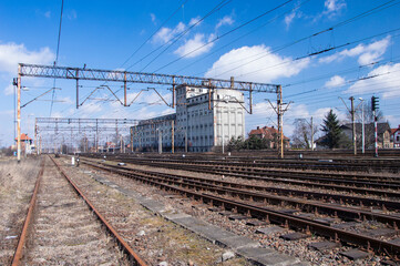 Railway infrastructure, tracks, rails and power cables over the tracks. Day.