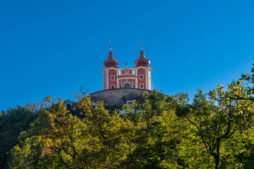 Fototapeta na wymiar view of the red Calvary Banska Stiavnica under a blue sky with forest in foreground