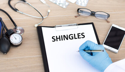 Doctor holding a card with text Shingles,medical concept