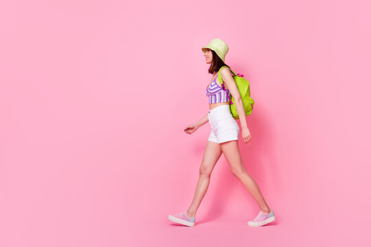 Full length photo of active pretty young girl spending free time camping hiking wear stylish singlet cap isolated on pink color background